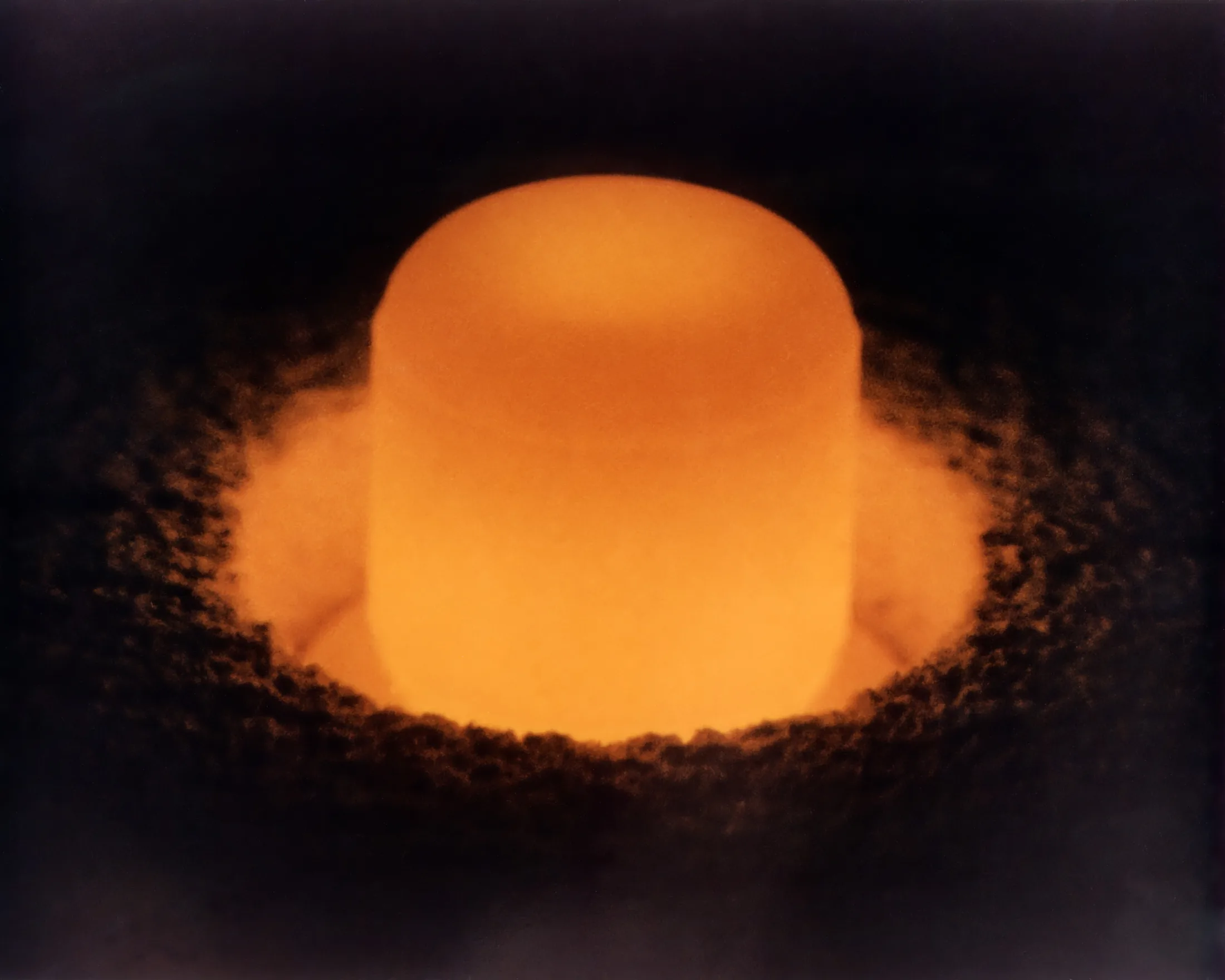 Plutonium-238 oxide pellet glowing under its own decay heat